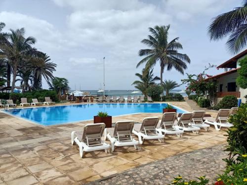 a row of lounge chairs next to a swimming pool at Sal&Love apt in Porto Antigo in Santa Maria
