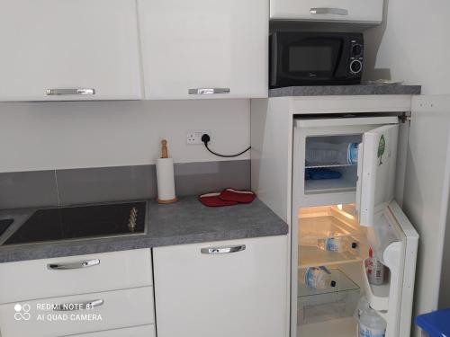 a small kitchen with a refrigerator and a microwave at Mellieha beach in Mellieħa