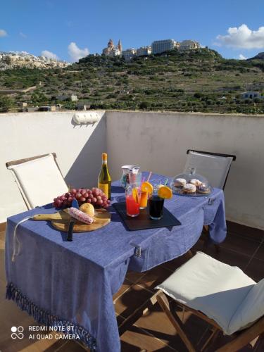 una mesa azul con comida y bebidas en el balcón en Mellieha beach, en Mellieħa