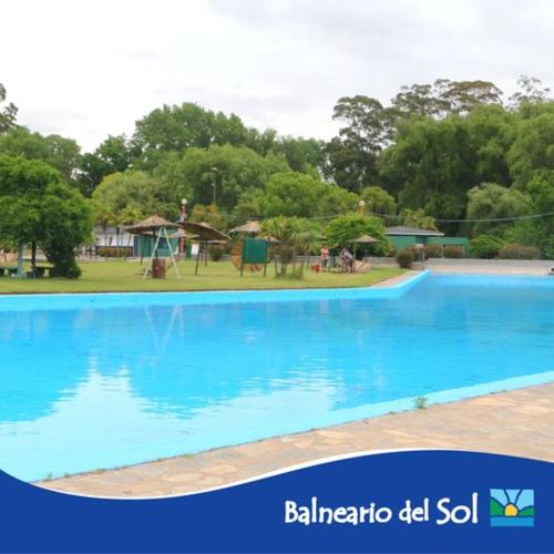 a large blue swimming pool in a park at La Casa de Liber in Tandil