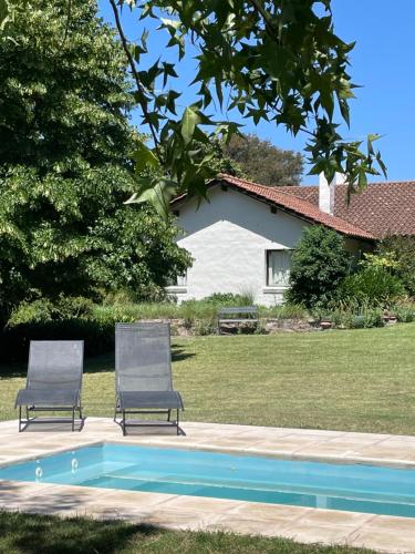 twee stoelen naast een zwembad bij GOLF - Casa de huéspedes in Tandil