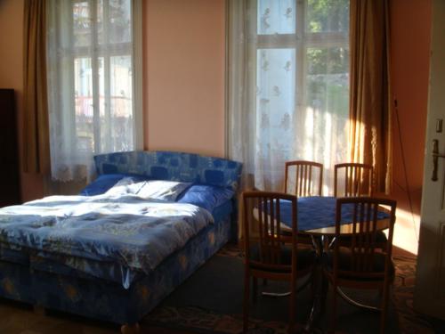 sypialnia z łóżkiem, stołem i krzesłami w obiekcie Villa Astrid w Jańskich Łaźniach