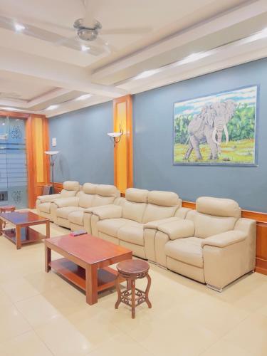 a living room with couches and a painting of an elephant at LEYSHOF HOTEL in Mwanza