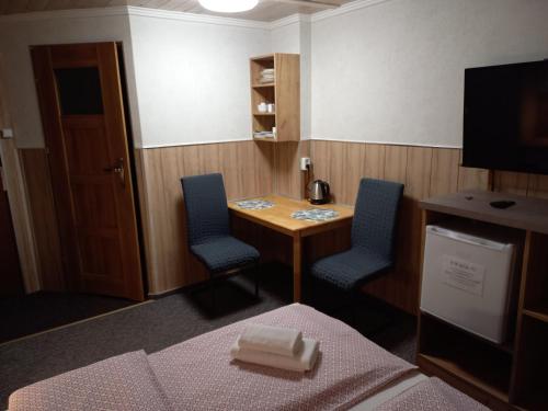 a room with a desk and two chairs and a table at Pokoje Gościnne Jaga in Kielce