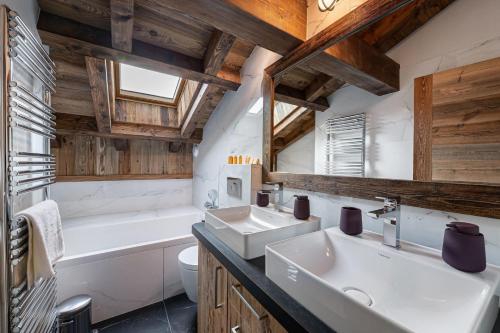a bathroom with two sinks and a tub and a toilet at Perfect for moments with friends or family in Oberstaufen