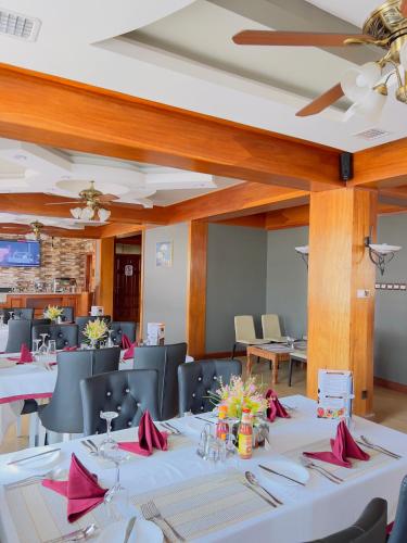 a dining room with white tables and chairs at LEYSHOF HOTEL in Mwanza