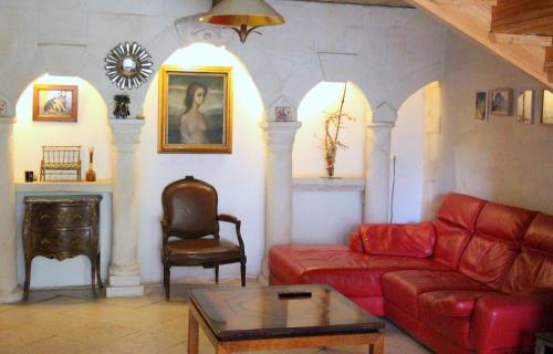 a living room with a red couch and a chair at Mas Du Petit Claux in Barbentane