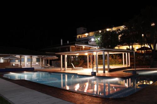 a swimming pool with a gazebo at night at Uzhupud Garden Hotel & Lodge in Paute
