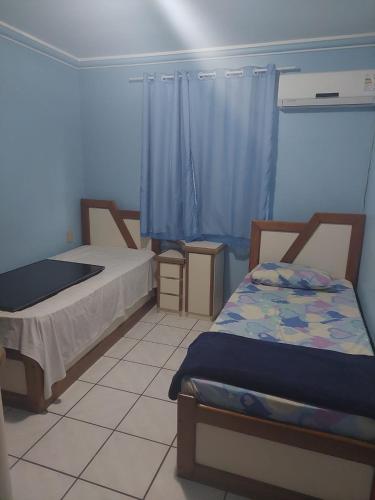 Cette petite chambre comprend 2 lits et une fenêtre. dans l'établissement Villa Saudade, à Porto Seguro