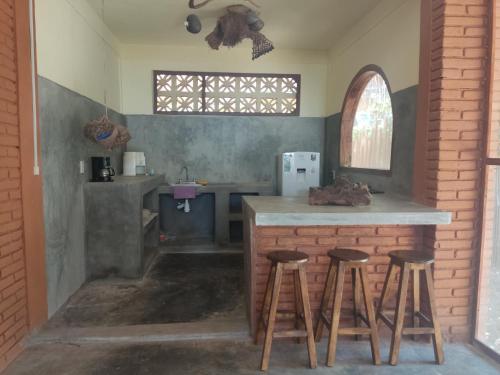 a kitchen with a counter and stools in a room at Casa Tonantzin in Zipolite
