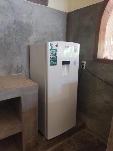 a white refrigerator in a corner of a room at Casa Tonantzin in Zipolite