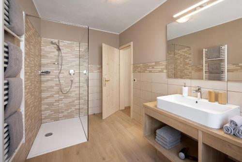 a bathroom with a sink and a shower at Hotel B&B Frohsinn in Badia