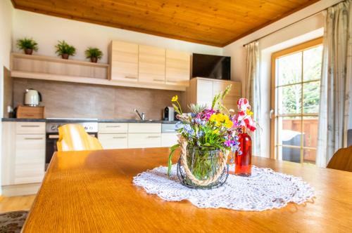 eine Vase mit Blumen auf dem Tisch in der Küche in der Unterkunft Appartement Reitlhof, Bio Berg Bauernhof in Krispl