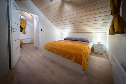 Schlafzimmer mit einem Bett mit Holzdecke in der Unterkunft Domki na Stoku in Wisła