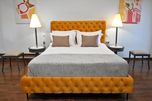 sypialnia z dużym pomarańczowym łóżkiem z 2 lampami w obiekcie Stylish Apartment, Acropolis view w Atenach