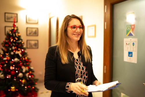 a woman standing in front of a christmas tree at Guest House Bella Onda in Tessera