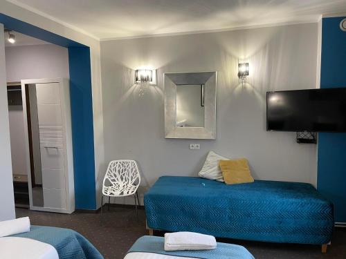 a room with a blue bed and a mirror at Inna Strefa - Sleep & Restaurant in Inowrocław