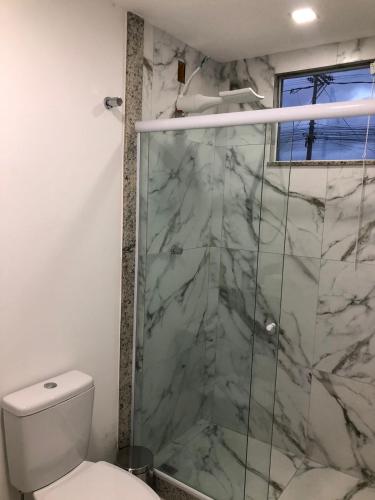a bathroom with a shower and a toilet at Pousada Litorânea in Saquarema
