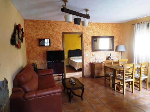 a living room with a couch and a dining room at Pago de Yuste - Casa Rural Apartamentos in Cuacos de Yuste
