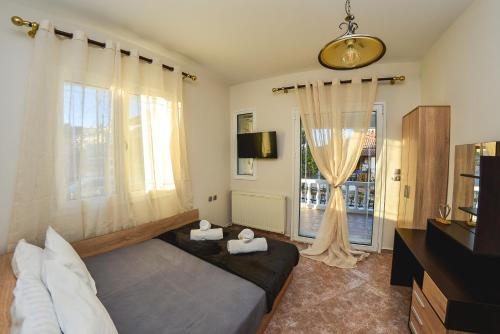 a bedroom with a bed and a large window at Bastasio airport skg in Tagarades