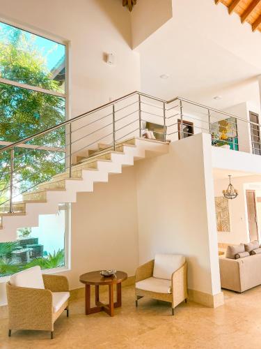 a living room with a spiral staircase in a house at Peninsula Esmeralda Luxury Villas in San Felipe de Puerto Plata
