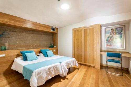 1 dormitorio con 1 cama grande con almohadas azules en Eco Suites Caves, en La Laguna