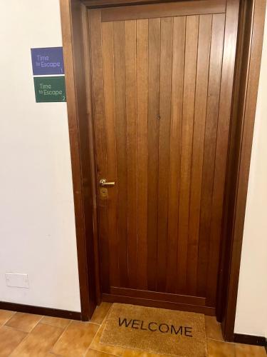 a wooden door with a welcome sign in front of it at TIME TO ESCAPE in Tirano