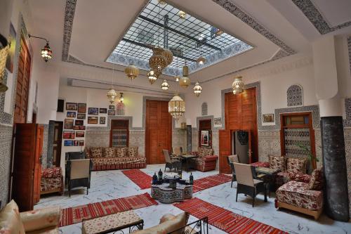 een grote woonkamer met banken en tafels en een plafond bij Riad bel kaid fes in Fès