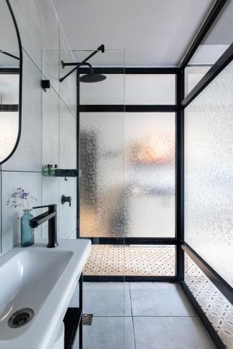a bathroom with a sink and a glass shower at Levinski Market Hotel in Tel Aviv