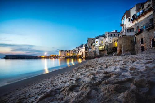 a view of a beach at night with buildings at Archi Bianchi in Cefalù