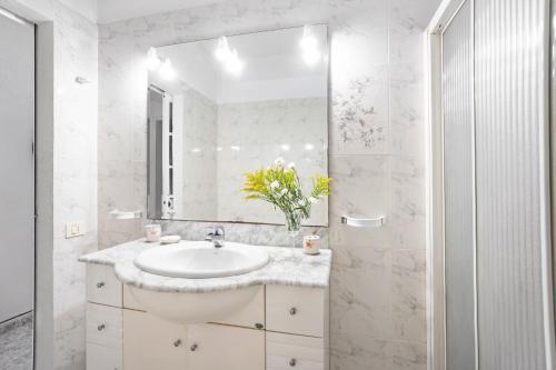 a white bathroom with a sink and a mirror at Apartamento Poris in Arico