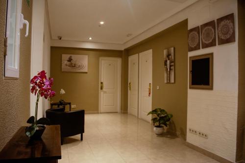 a hallway with a room with a door and flowers at Hostal Ártico in Madrid