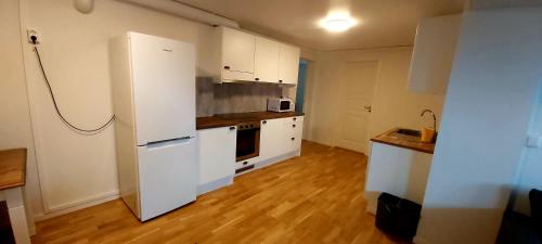 a kitchen with white cabinets and a white refrigerator at Aurora rooms for rent nr3 we are doing Northen Lights trip, Reaindear trip and Sommaroy Fjord trips in Tromsø