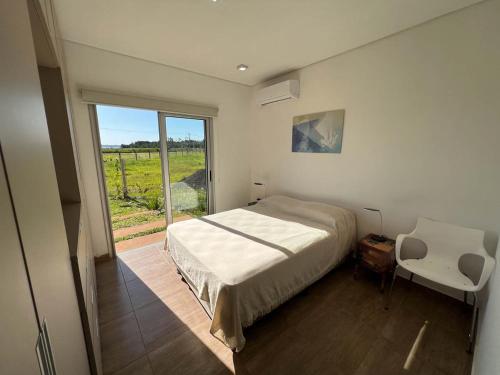 1 dormitorio con cama, ventana y silla en Casa Sunset - La Candelaria en Candelaria