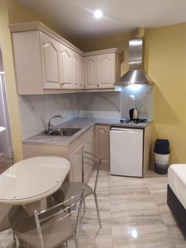 a kitchen with white cabinets and a table and a sink at SMILE in Platamonas