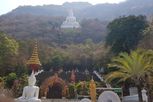 a buddhist temple with a large building in the background at Villa Noina Glamping in Ban Nong Takhain