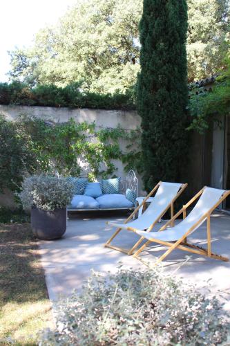 two lounge chairs and a couch in a garden at Maison Les Chênes in Eygalières