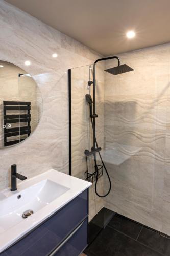 une salle de bain avec un lavabo et une douche dans l'établissement Le Jardin de Babylone 