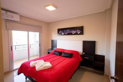 1 dormitorio con cama roja y manta roja en Barrio Norte-new apt - con Pileta en San Miguel de Tucumán