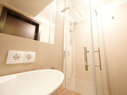 a bathroom with a shower and a white tub at Apartments at Winterhafen in Linz