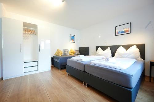 a bedroom with two beds and a couch at Apartments at Winterhafen in Linz