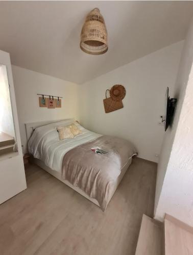 une chambre avec un lit dans une pièce blanche dans l'établissement ELLE Loc St-Brévin, à Saint-Brévin-les-Pins