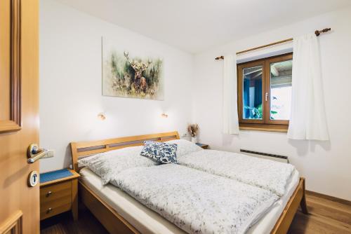 een slaapkamer met een bed en een raam bij Die Lärchen-Lodge in Maishofen