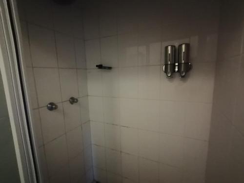 a bathroom with a shower with white tile at Aloe Cottage - Ramsgate Ramble Rest in Margate