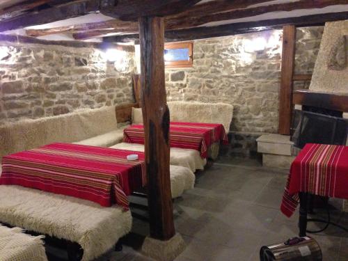 fila de camas en una habitación con paredes de piedra en Guest House Galba, en Brŭchkovtsi