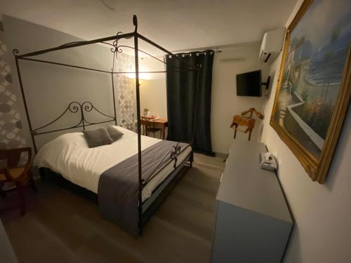 a bedroom with a canopy bed and a table at La Roselière in Saint-Quentin-Fallavier