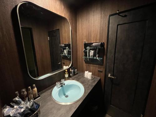 a bathroom with a sink and a mirror at 旭川ホテルユニオン-大人専用 in Asahikawa