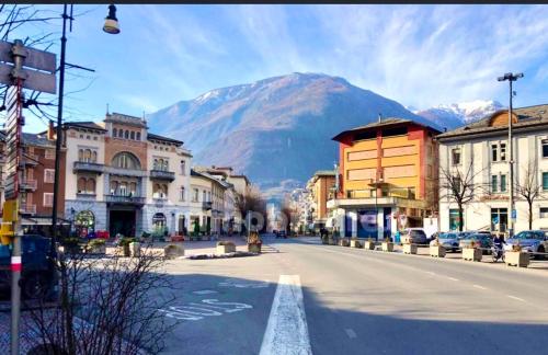 una calle en una ciudad con una montaña en el fondo en TIME TO ESCAPE, en Tirano