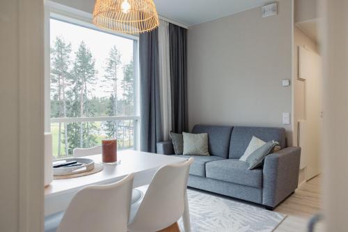 ein Wohnzimmer mit Tisch und Couch in der Unterkunft Asunto Kalajoen Golfpuistossa in Kalajoki