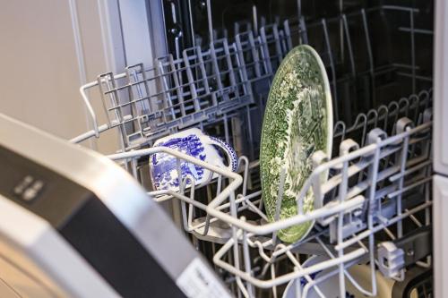 a dish drying rack with dishes and plates in a dishwasher at Chalet Antoine serviced Apartments by Mirabeau in Zermatt